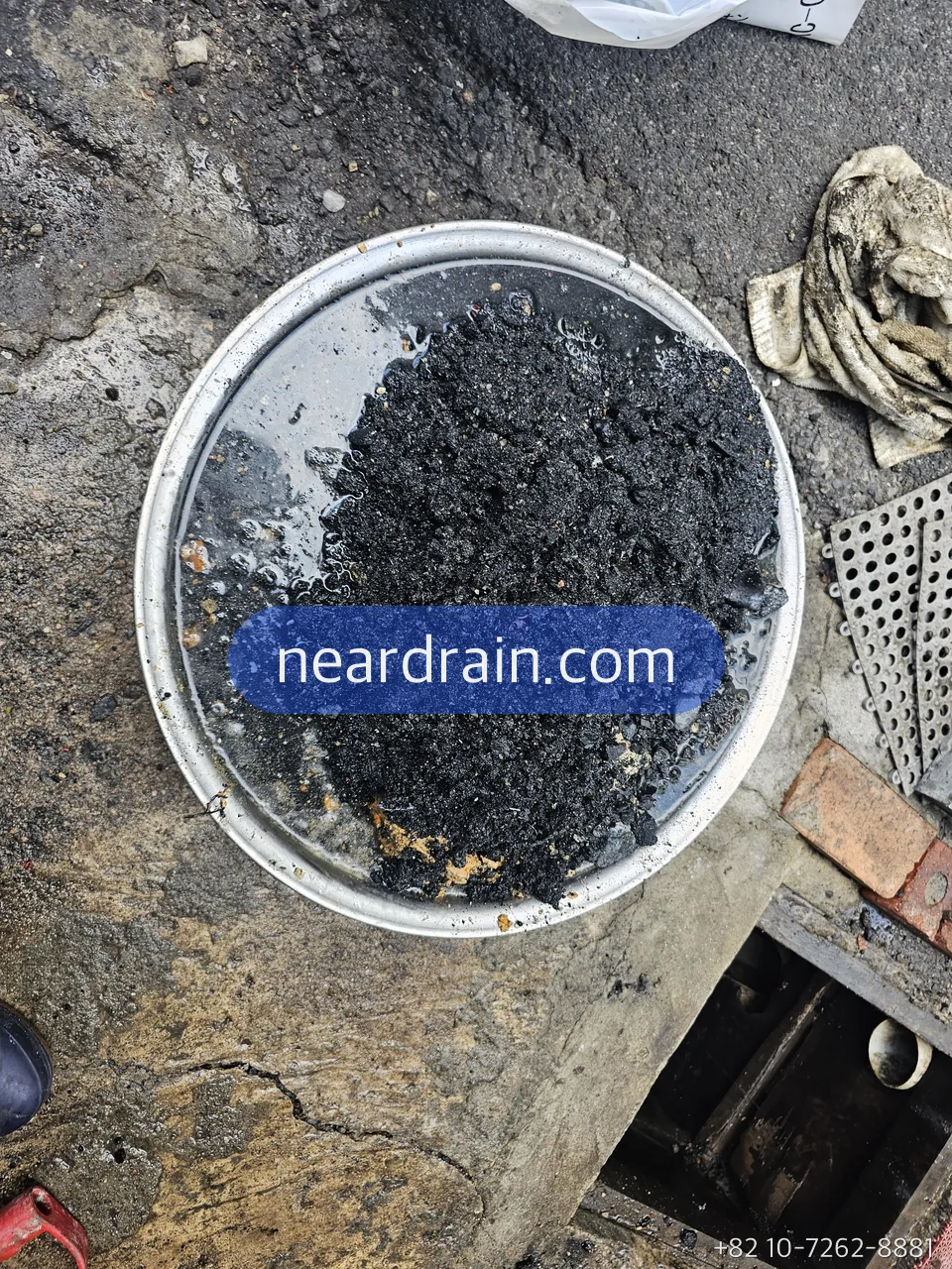 Grease sludge scooped out of a restaurant trench drain into a strainer