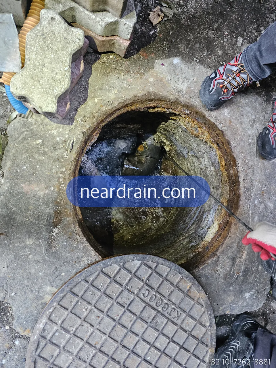 Manhole in front of a shop opened before opening hours for jetting