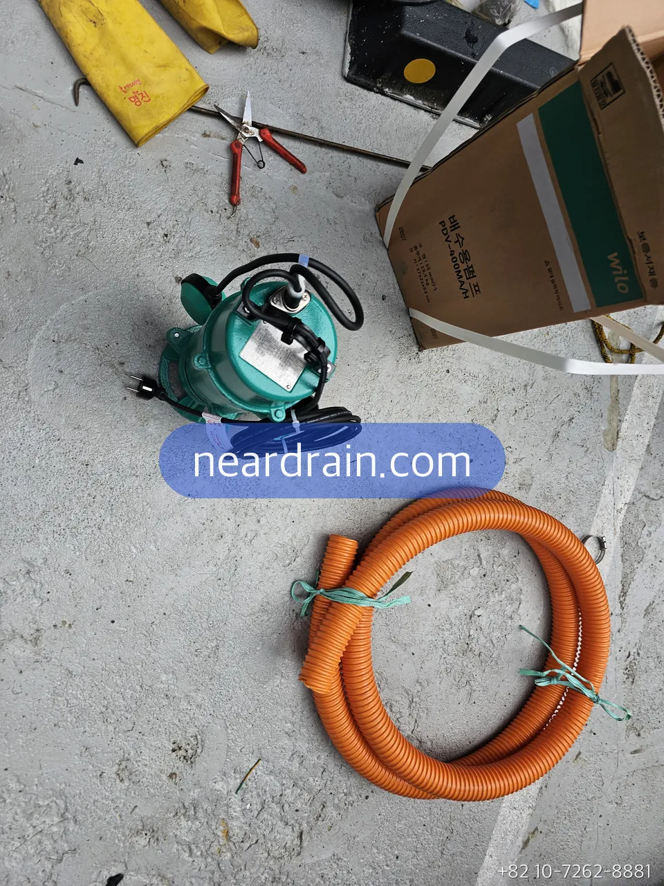 Submersible pump with its discharge hose lifted out of a pit