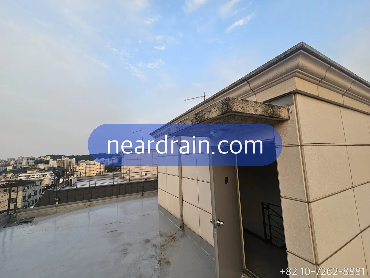 Rooftop terrace of a Seoul villa after rain, wet floor and the drain corner where water collects