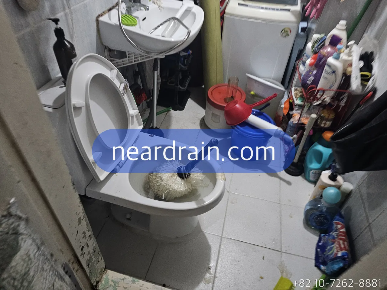 Toilet bowl in a villa bathroom packed with a white mass of wet wipes, a retrieval tool resting in the bowl